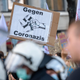 An anti-lockdown protester holds up a poster reading “Against Coronazis” during a demonstration of Germany’s “Querdenker” (Lateral Thinkers) movement on November 6, 2021 in Leipzig, eastern Germany.
